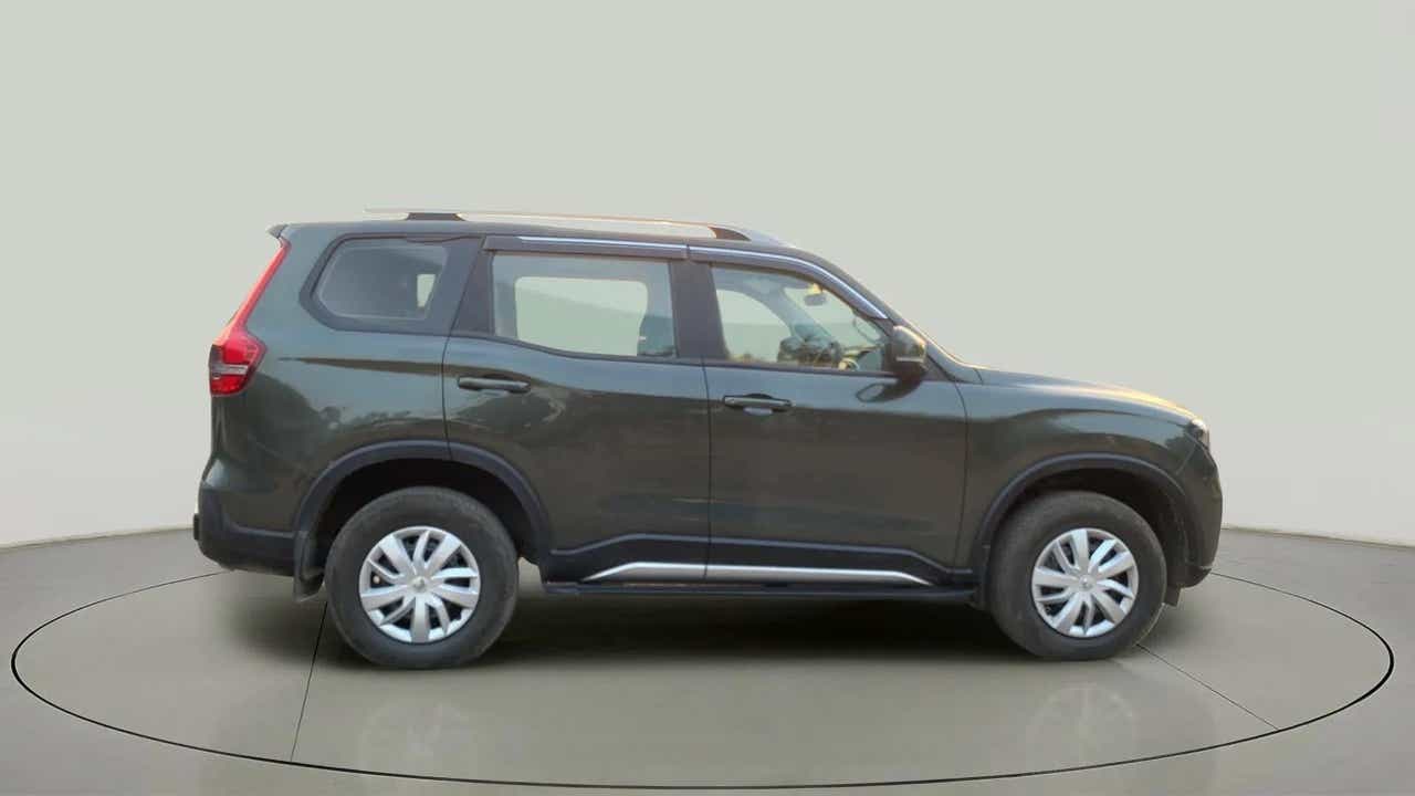 Side view of a deep forest Mahindra Scorpio-N