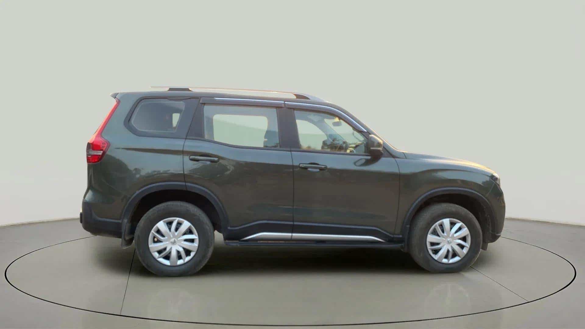 Side view of a deep forest Mahindra Scorpio-N