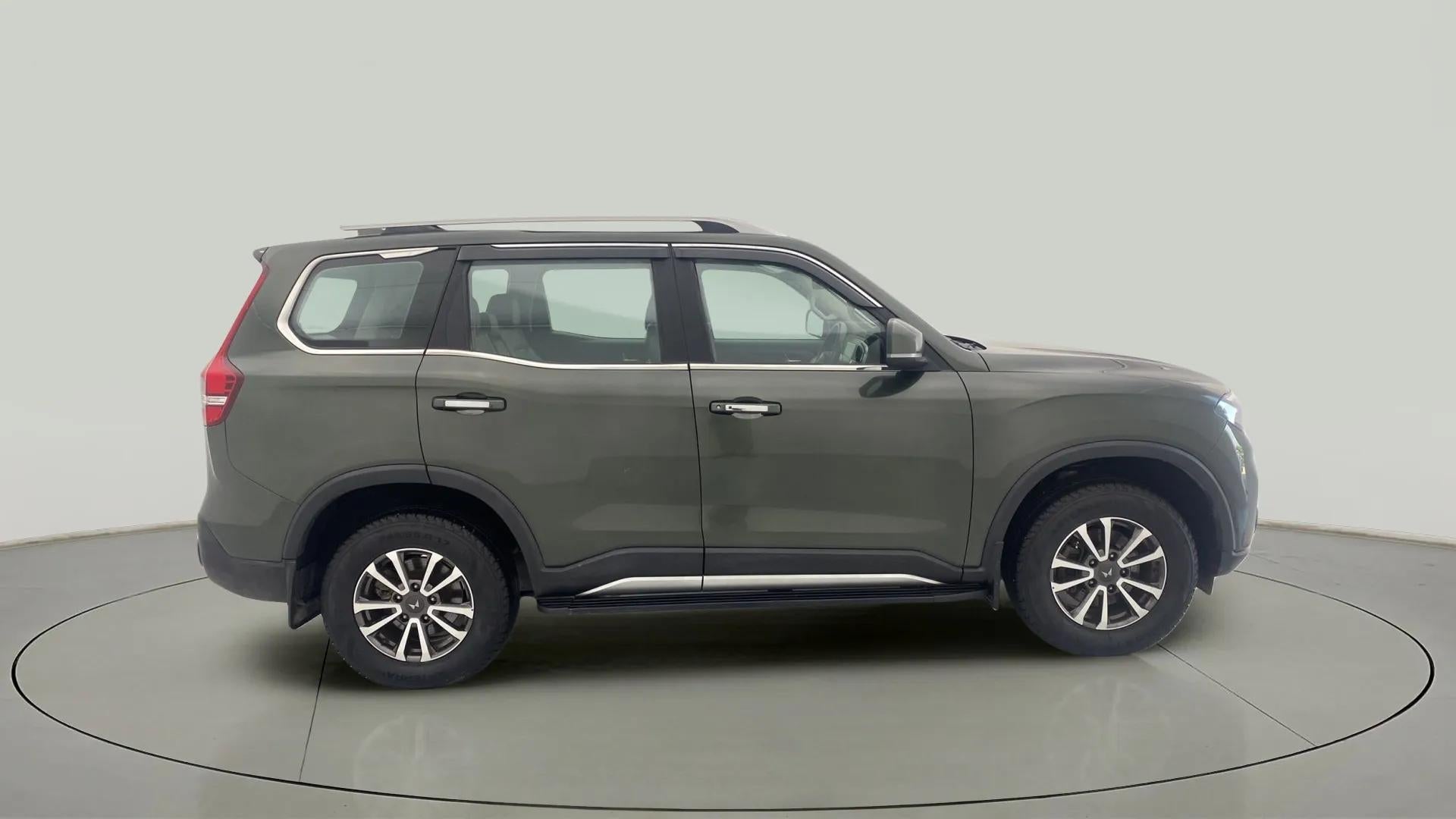 Side view of a deep forest Mahindra Scorpio-N