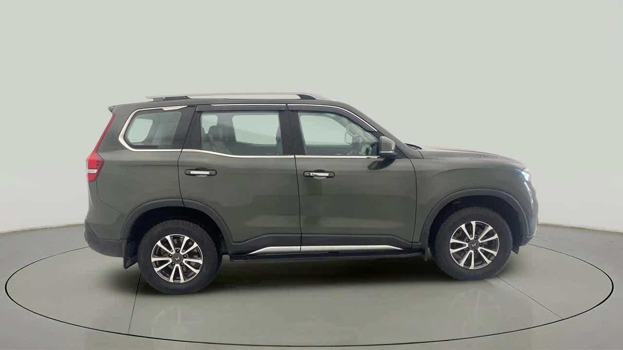 Side view of a deep forest Mahindra Scorpio-N