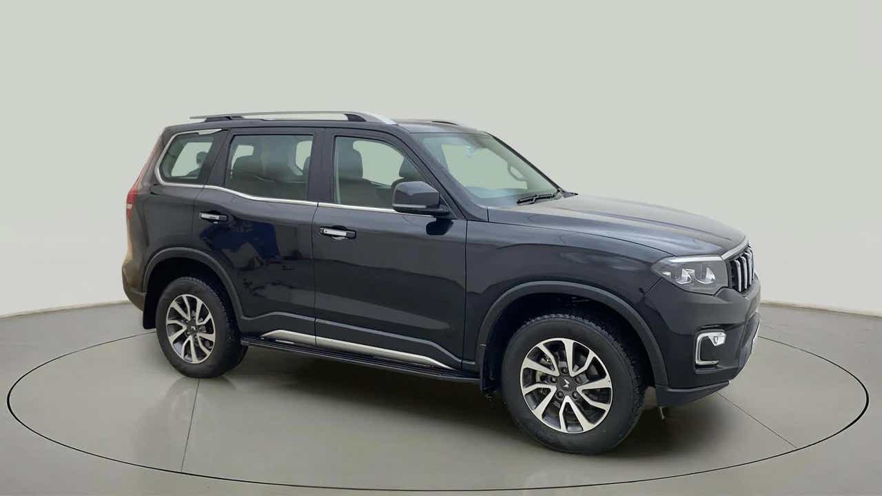 Side view of a deep forest Mahindra Scorpio-N