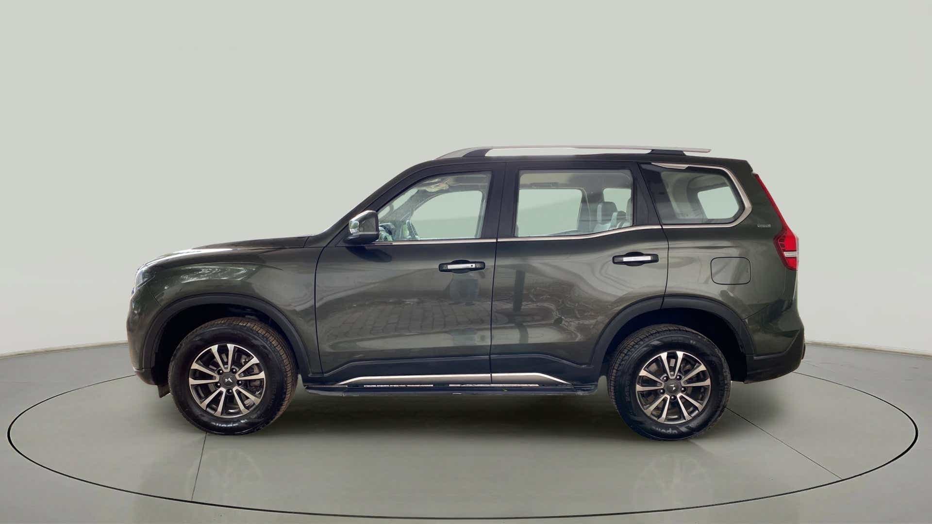Side view of a deep forest Mahindra Scorpio-N