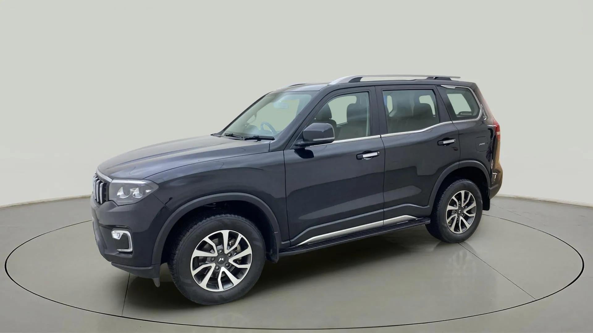 Side view of a deep forest Mahindra Scorpio-N