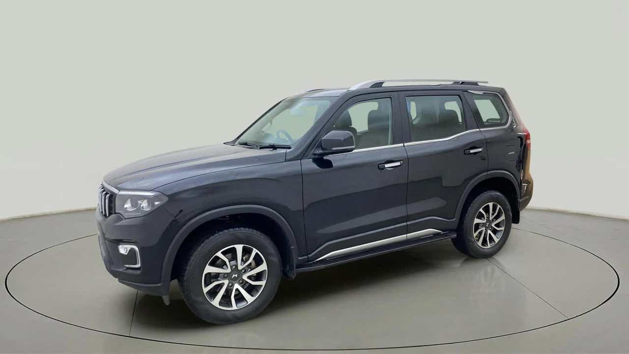 Side view of a deep forest Mahindra Scorpio-N