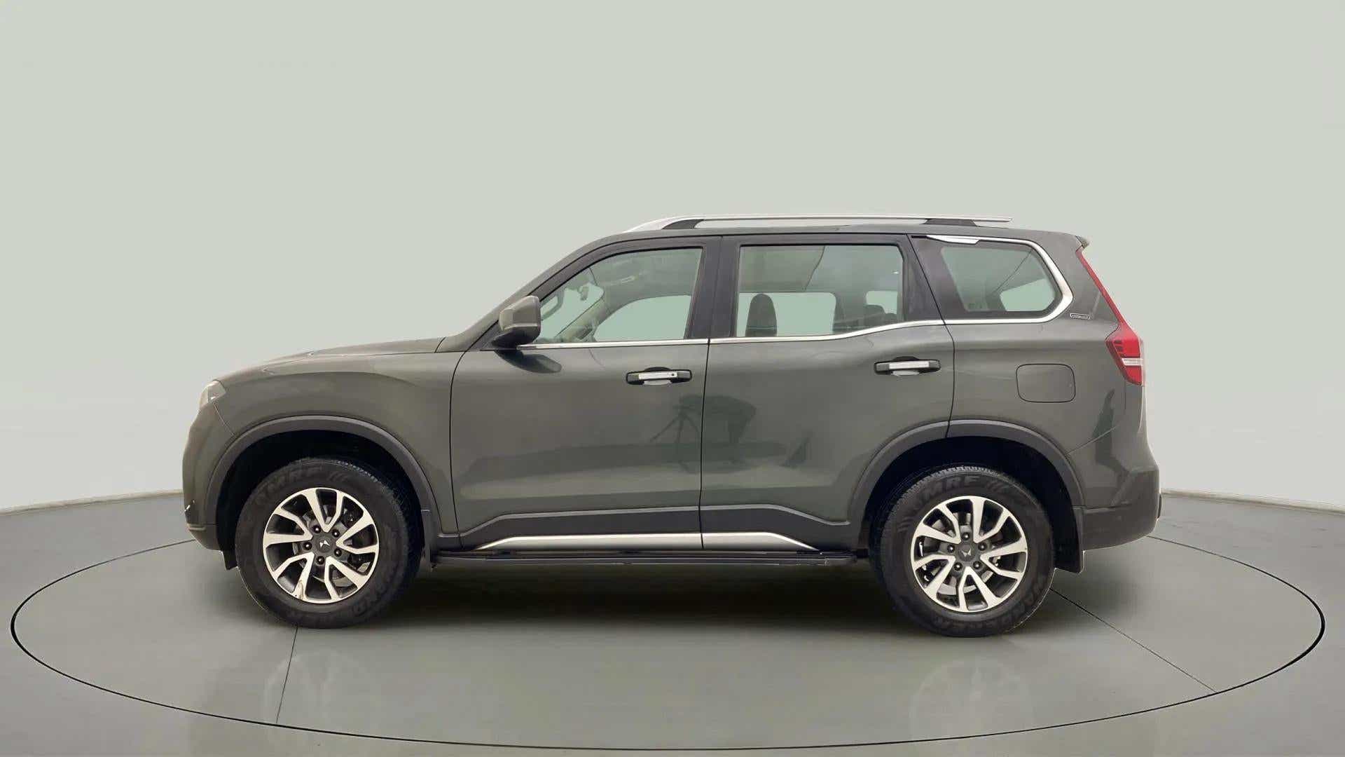 Side view of a deep forest Mahindra Scorpio-N
