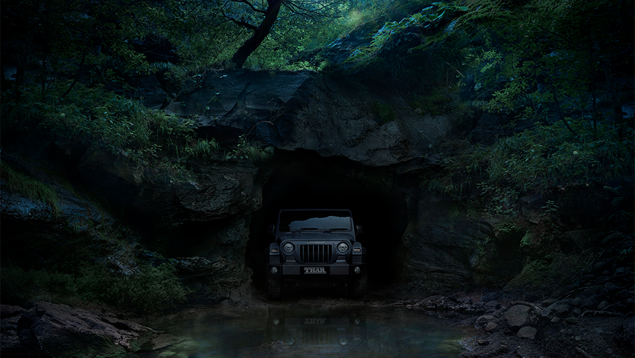 Front view of a Mahindra Thar emerging from a cave