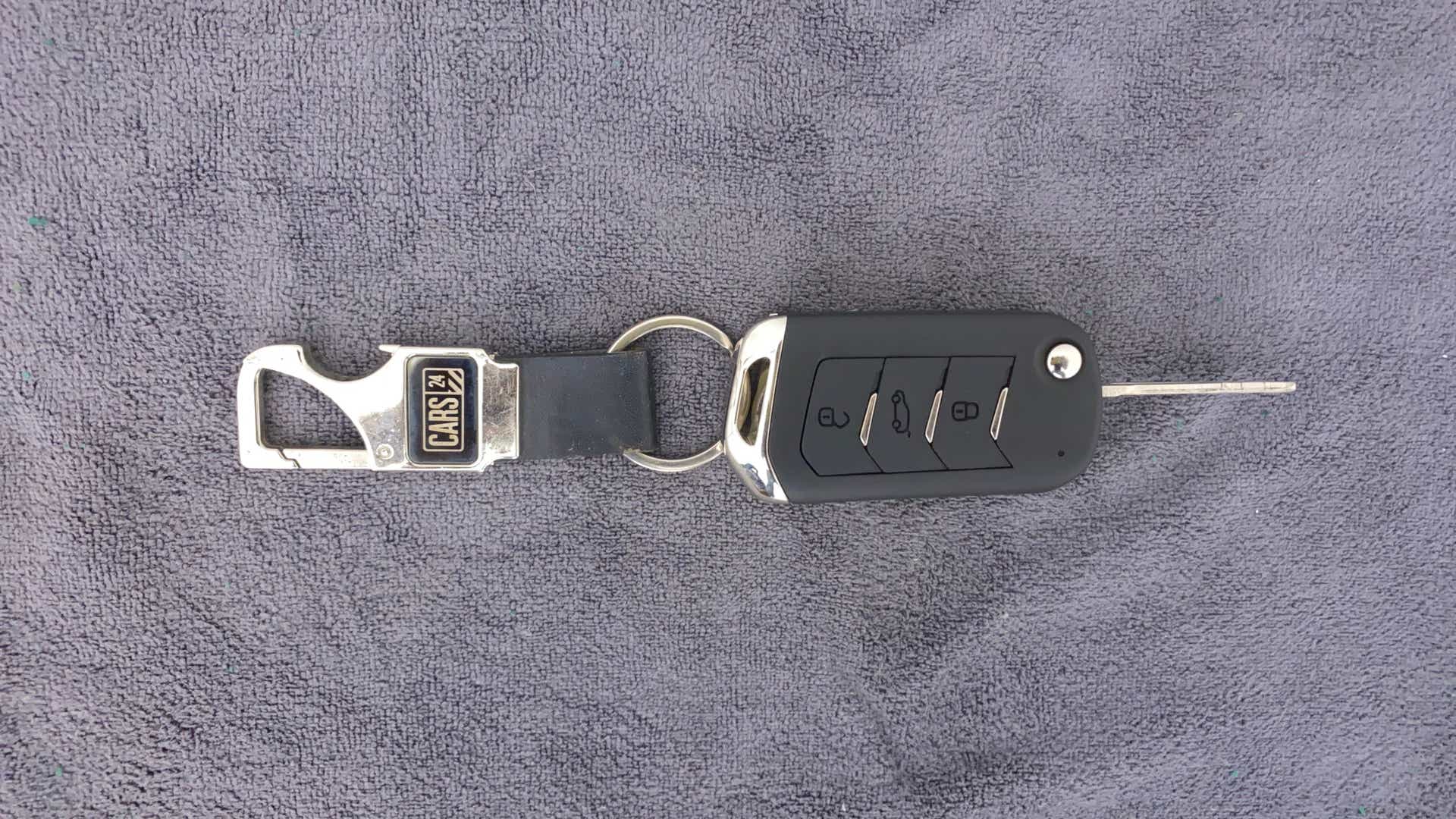 Car key with keychain on a flat surface
