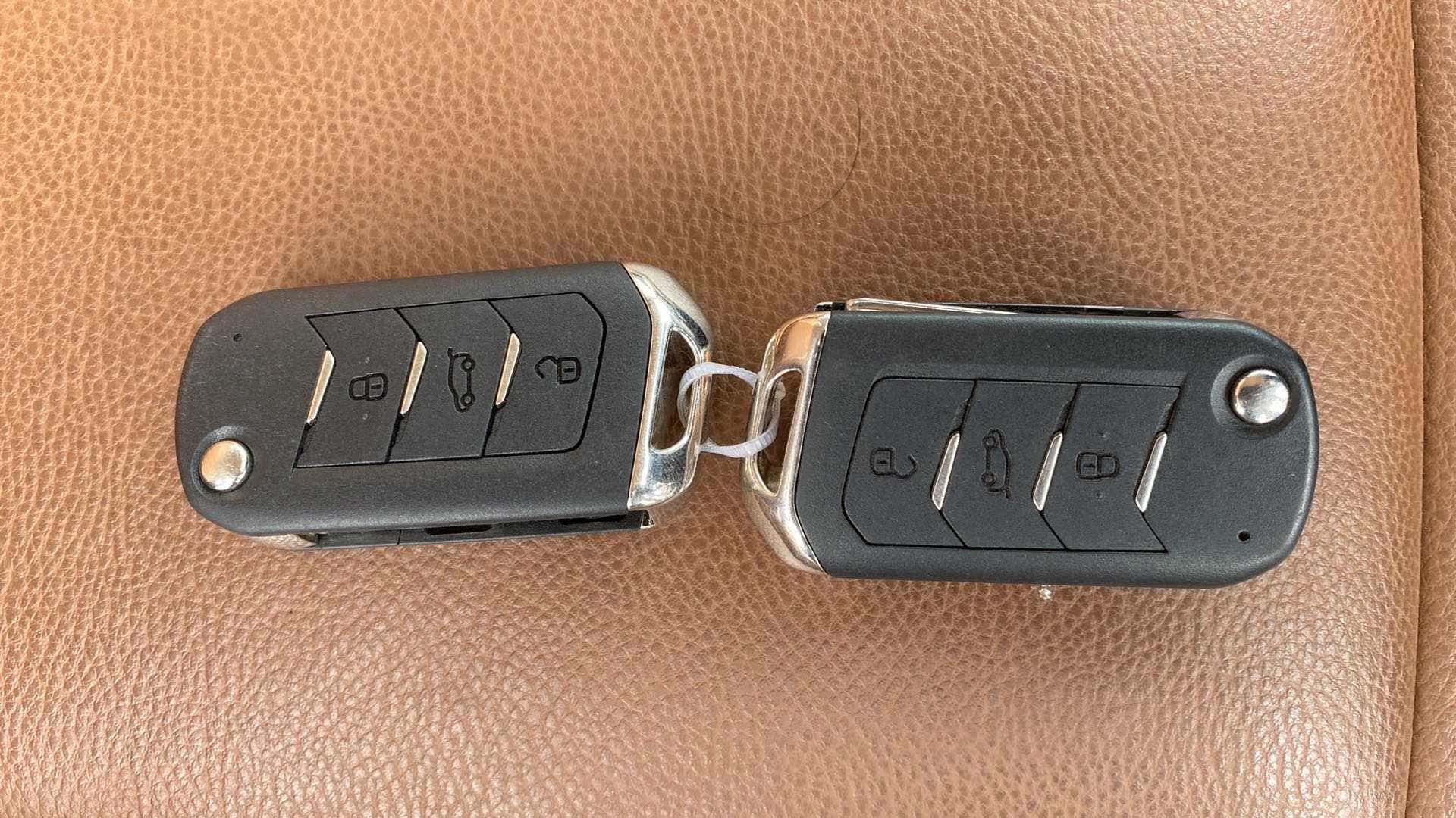 Car key fobs on brown leather seat for a Mahindra XUV700