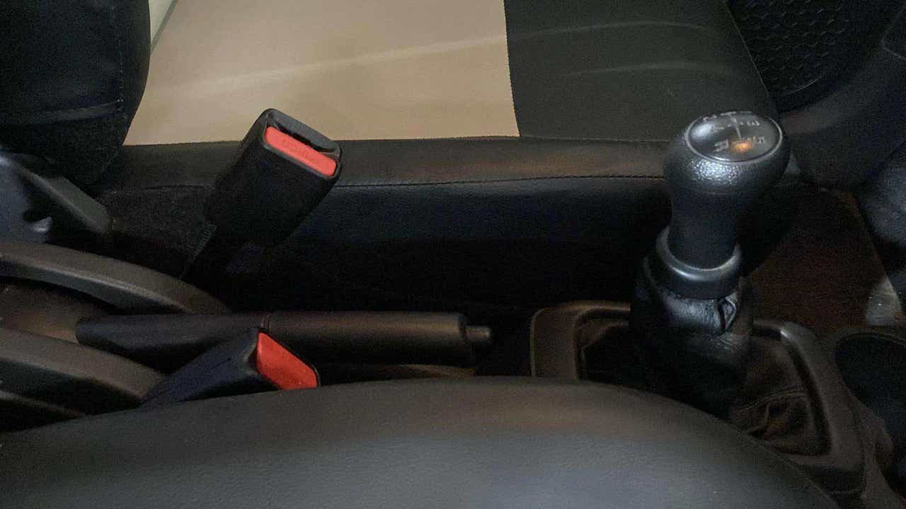 Center console with gear lever and seatbelt buckles of a Maruti Suzuki Alto K10
