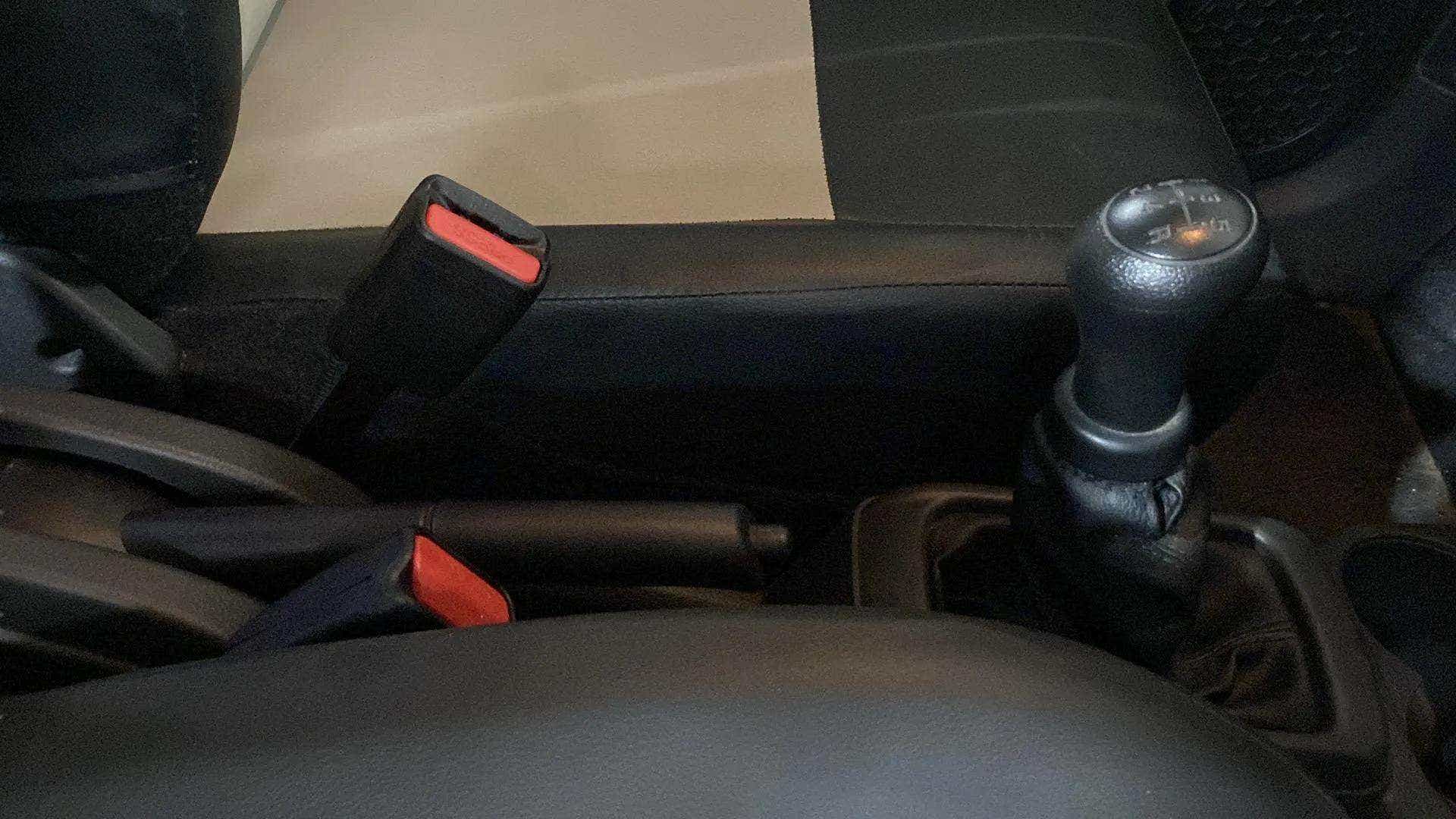 Center console with gear lever and seatbelt buckles of a Maruti Suzuki Alto K10