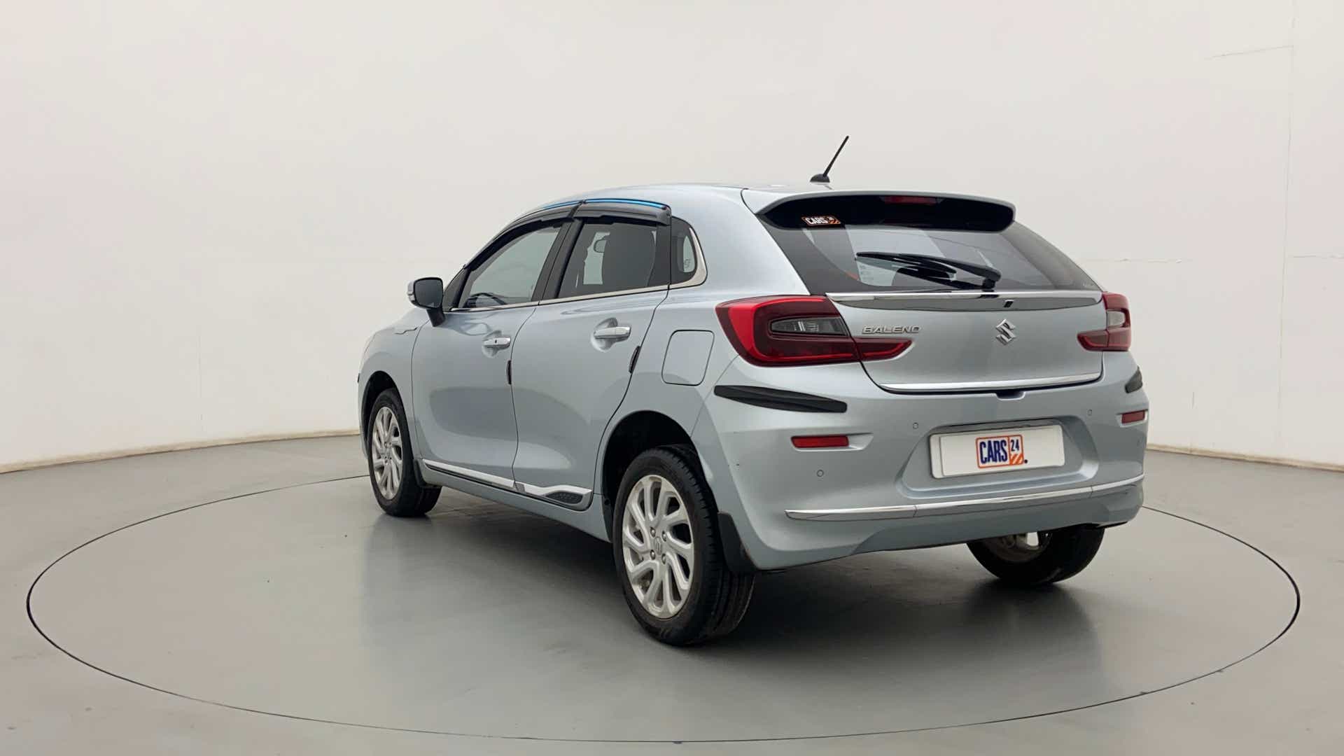 Rear three-quarter of a Splendid Silver Maruti Suzuki Baleno