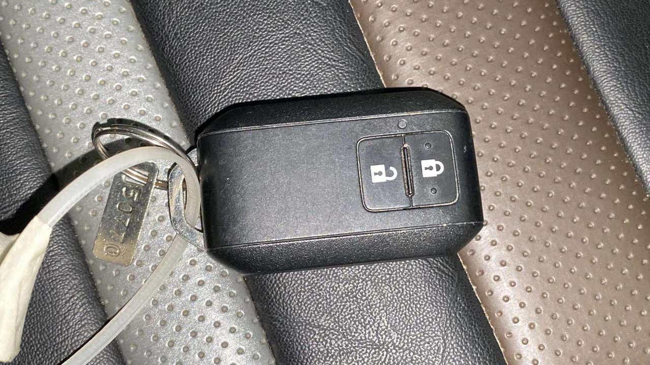 Car key fob on a leather seat of a Maruti Suzuki Brezza