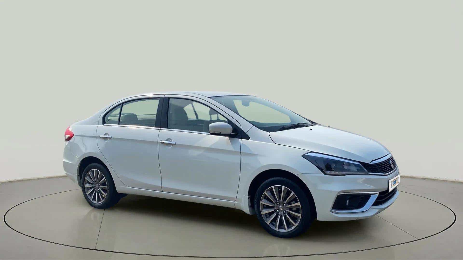Front and side view of a Pearl Arctic White Maruti Suzuki Ciaz