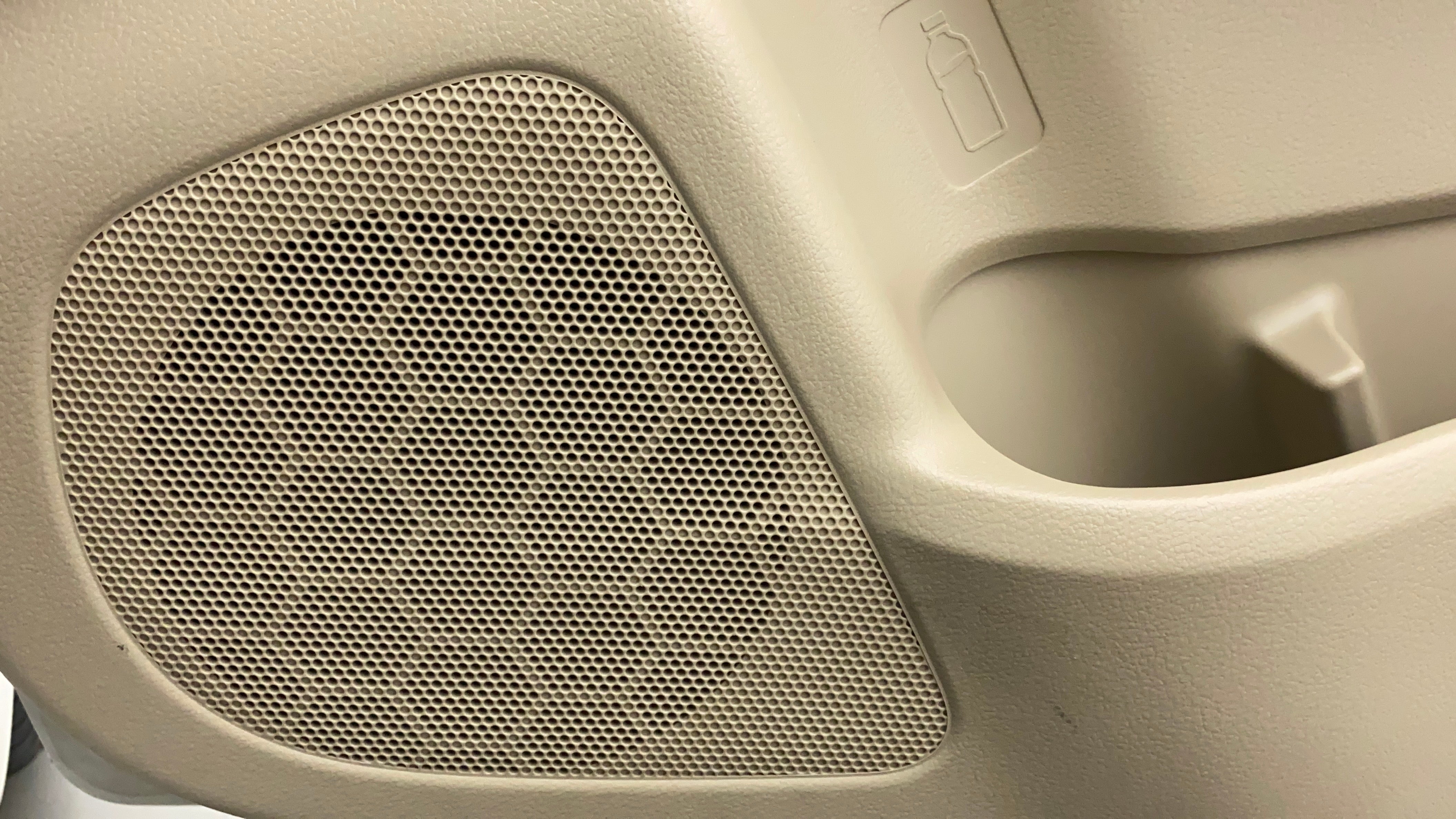 Close-up of an interior speaker grille and bottle holder of a Maruti Suzuki Ciaz