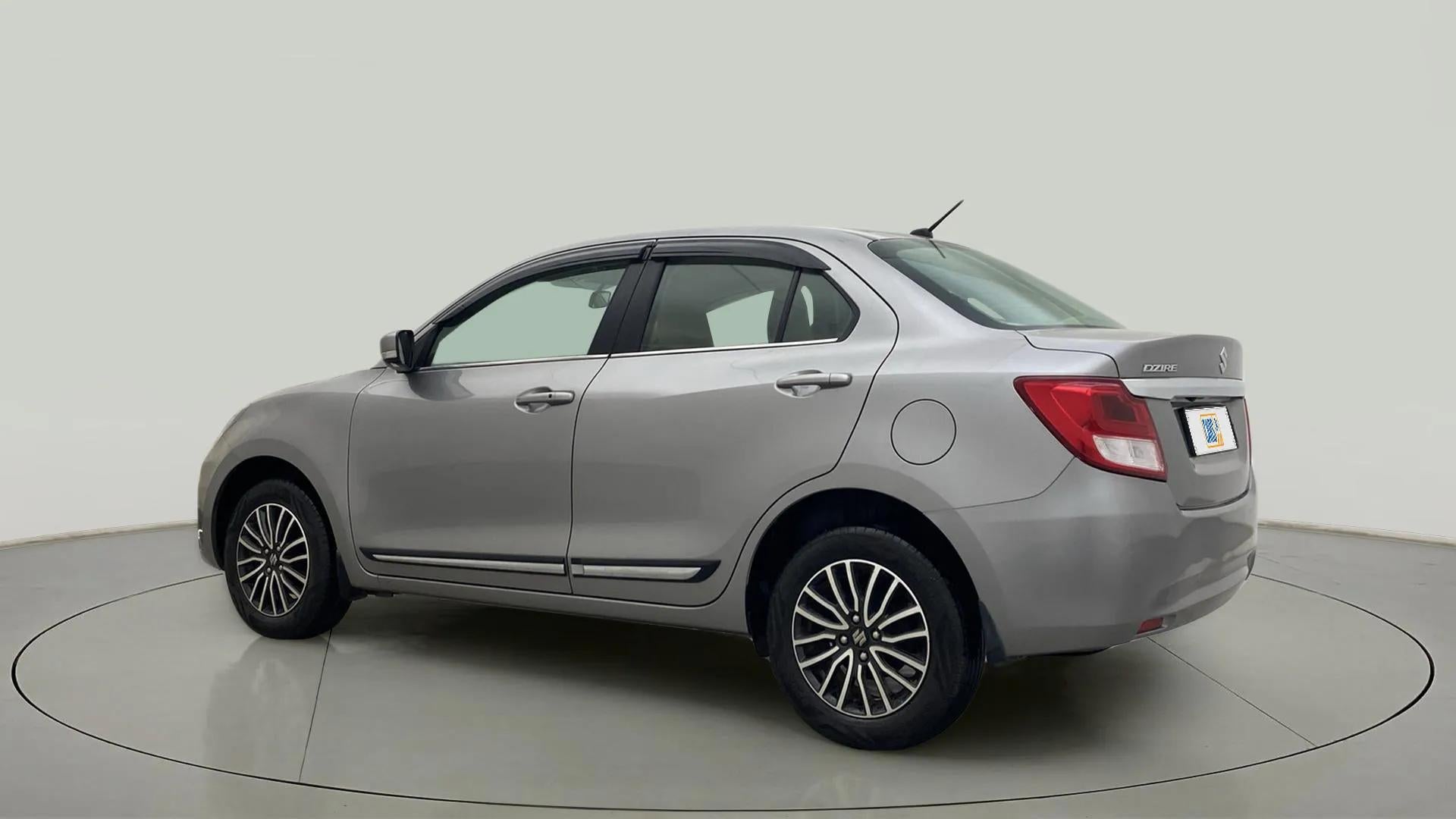 Rear three-quarter of a Splendid Silver Maruti Suzuki Dzire 2018-2023