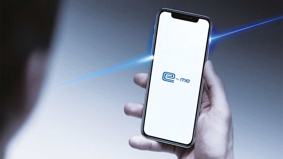 Person holding a smartphone showing the car app interface of a Maruti Suzuki e Vitara