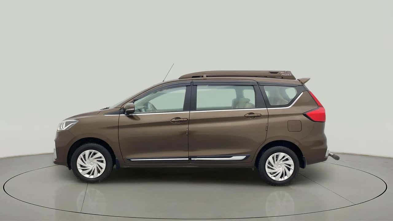 Left side view of a Pearl Metallic Dignity Brown Maruti Suzuki Ertiga