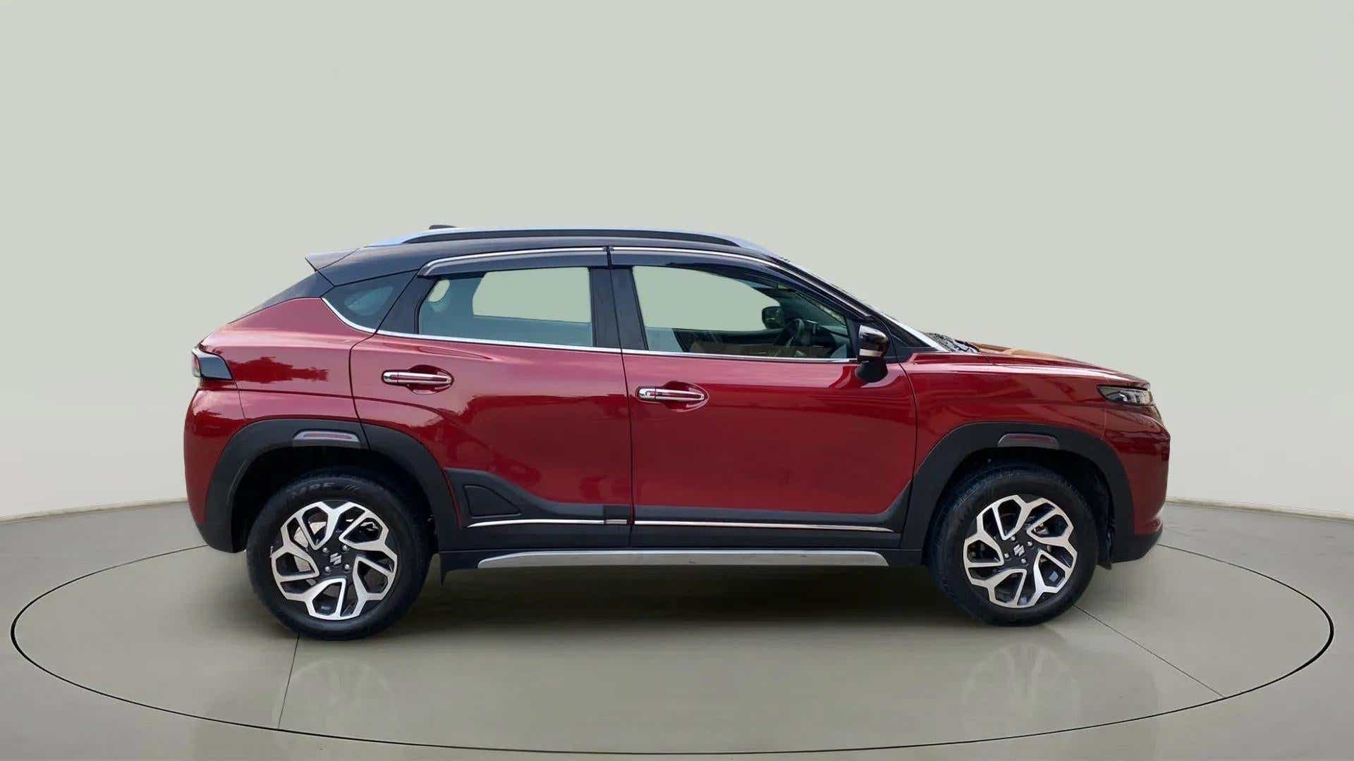 Side view of a opulent red with blusih black Maruti Suzuki FRONX