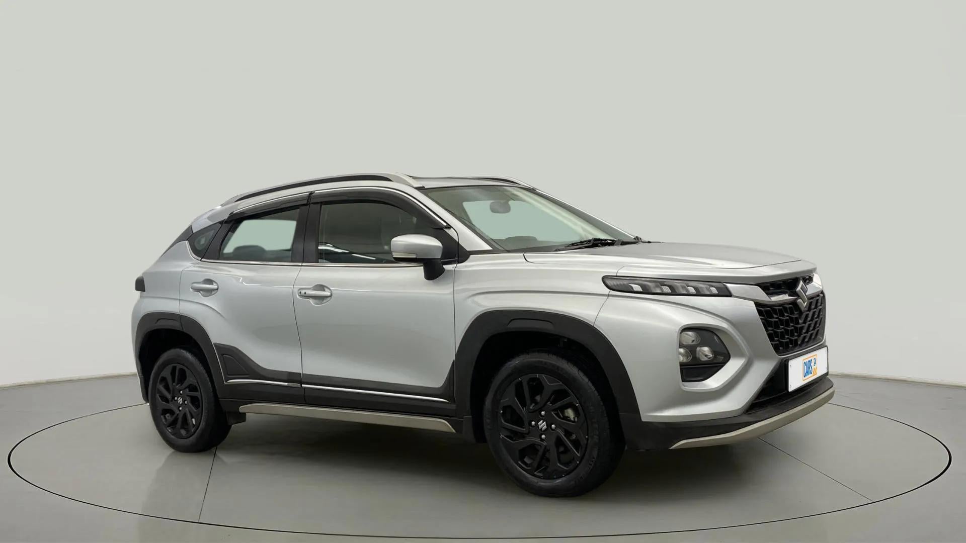 Front and side view of a Splendid Silver With Black Maruti Suzuki FRONX