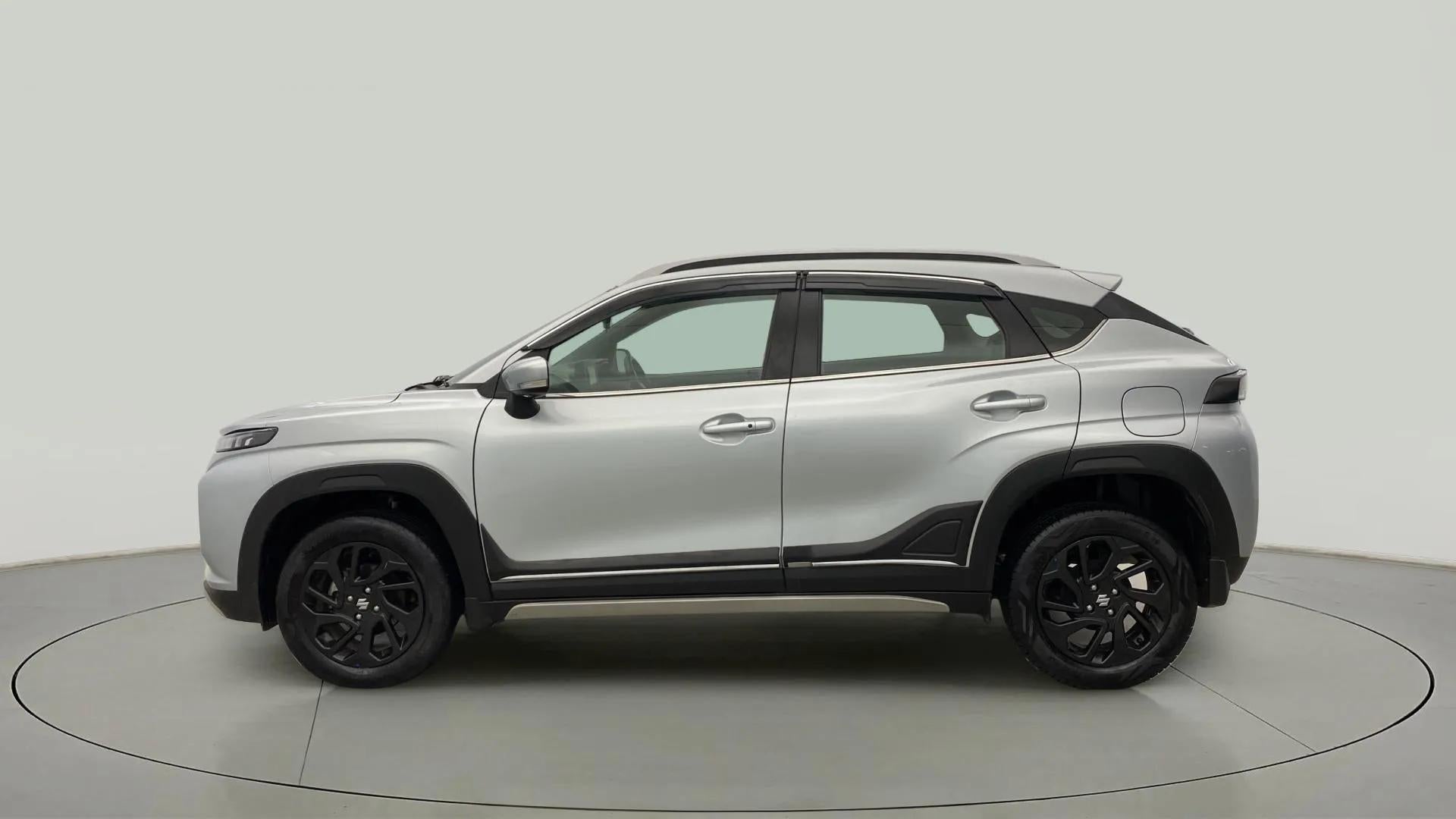 Side profile of a splendid silver with black Maruti Suzuki FRONX