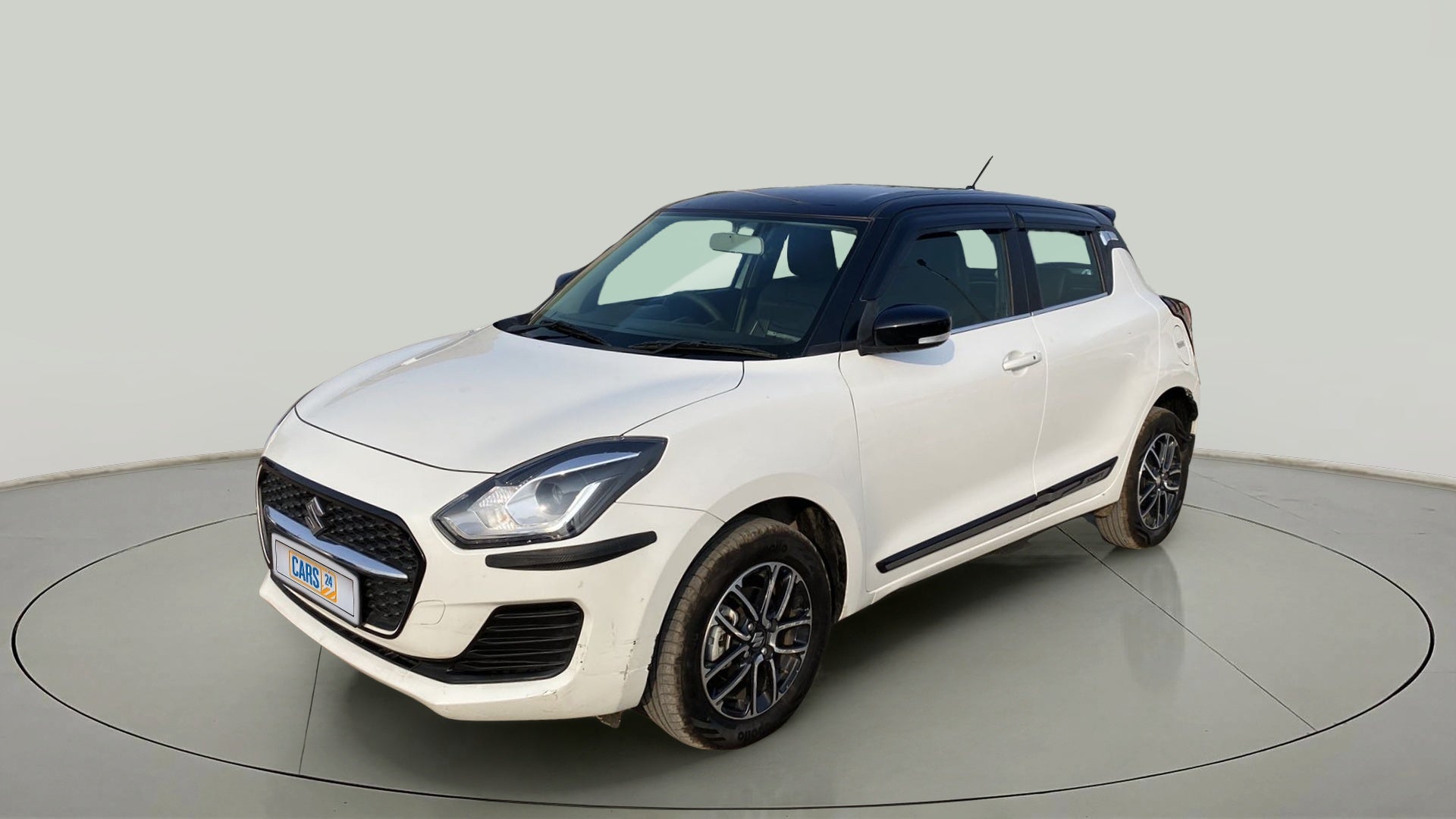 Front three-quarter view of a Pearl Arctic White with Pearl Midnight Black roof Maruti Suzuki Swift 2021 - 2023