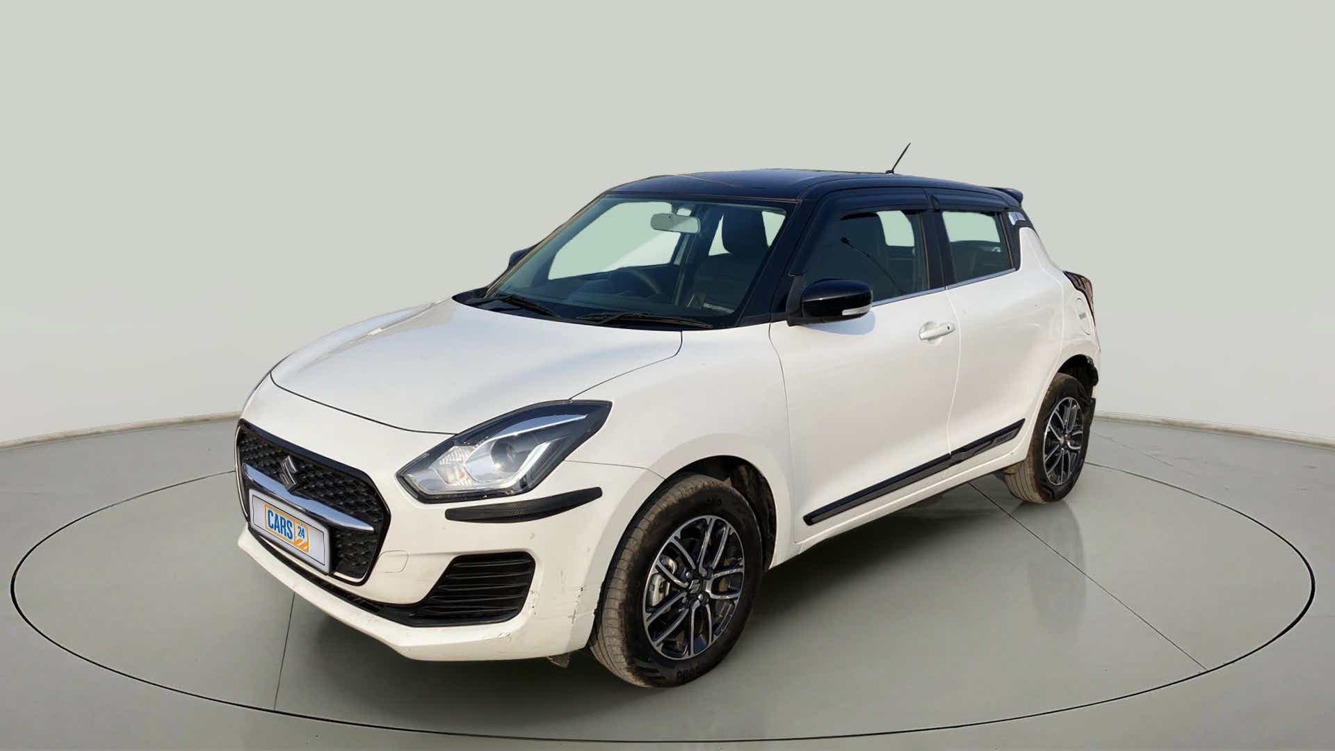 Front three-quarter view of a Pearl Arctic White with Pearl Midnight Black roof Maruti Suzuki Swift 2021 - 2023