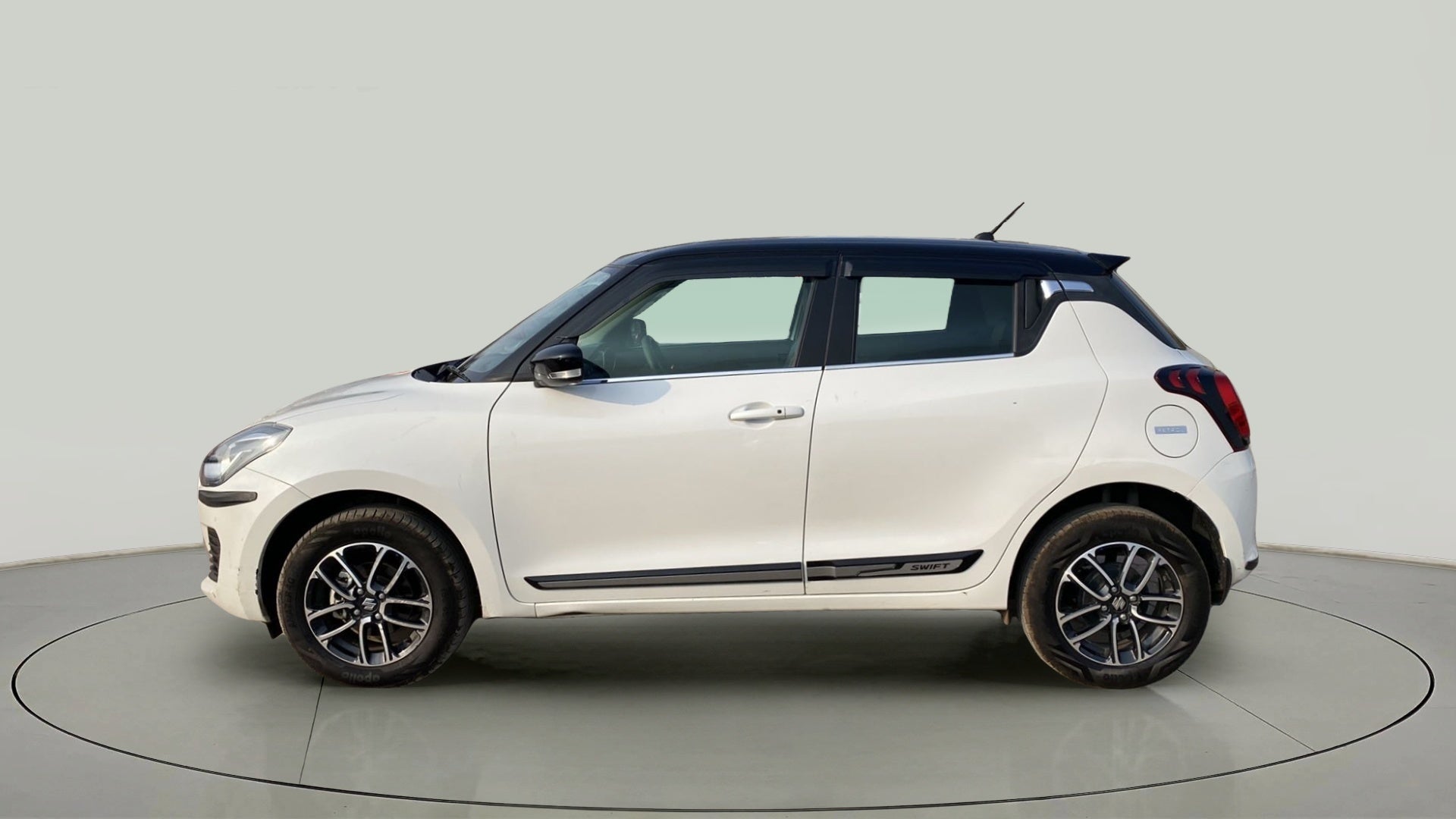 Side view of a pearl arctic white with pearl midnight black roof Maruti Suzuki Swift 2021 - 2023