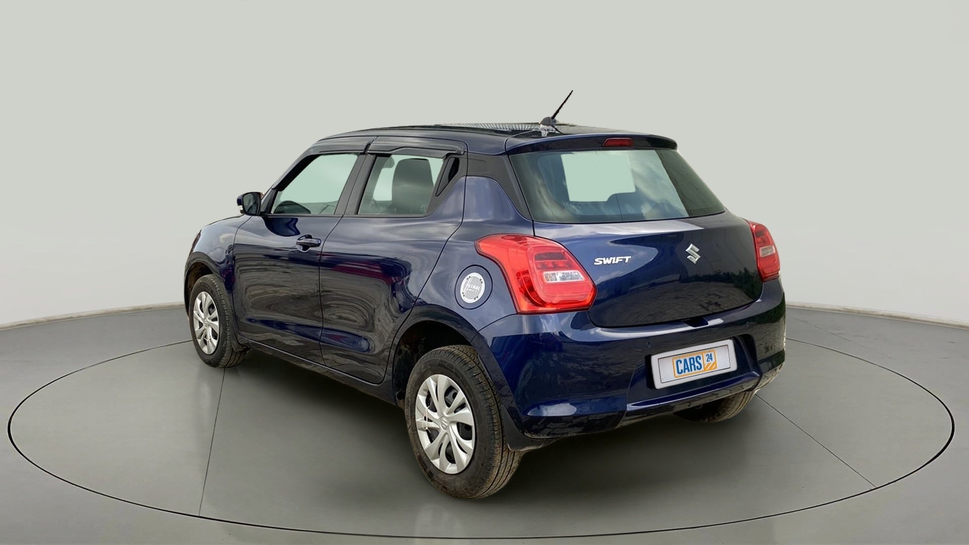 Rear three-quarter view of a pearl-metallic-midnight-blue Maruti Suzuki Swift 2021 - 2023
