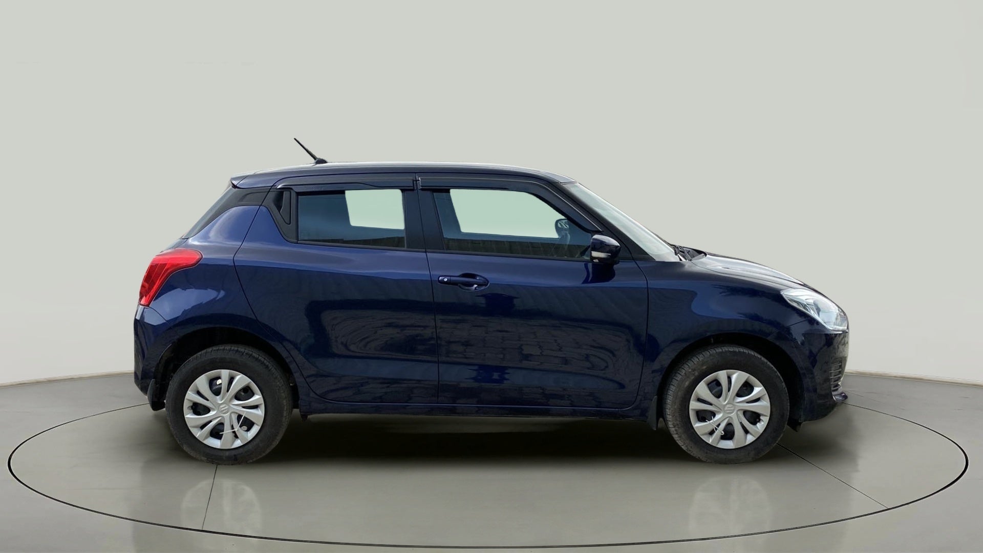Side view of a pearl metallic midnight blue Maruti Suzuki Swift 2021 - 2023