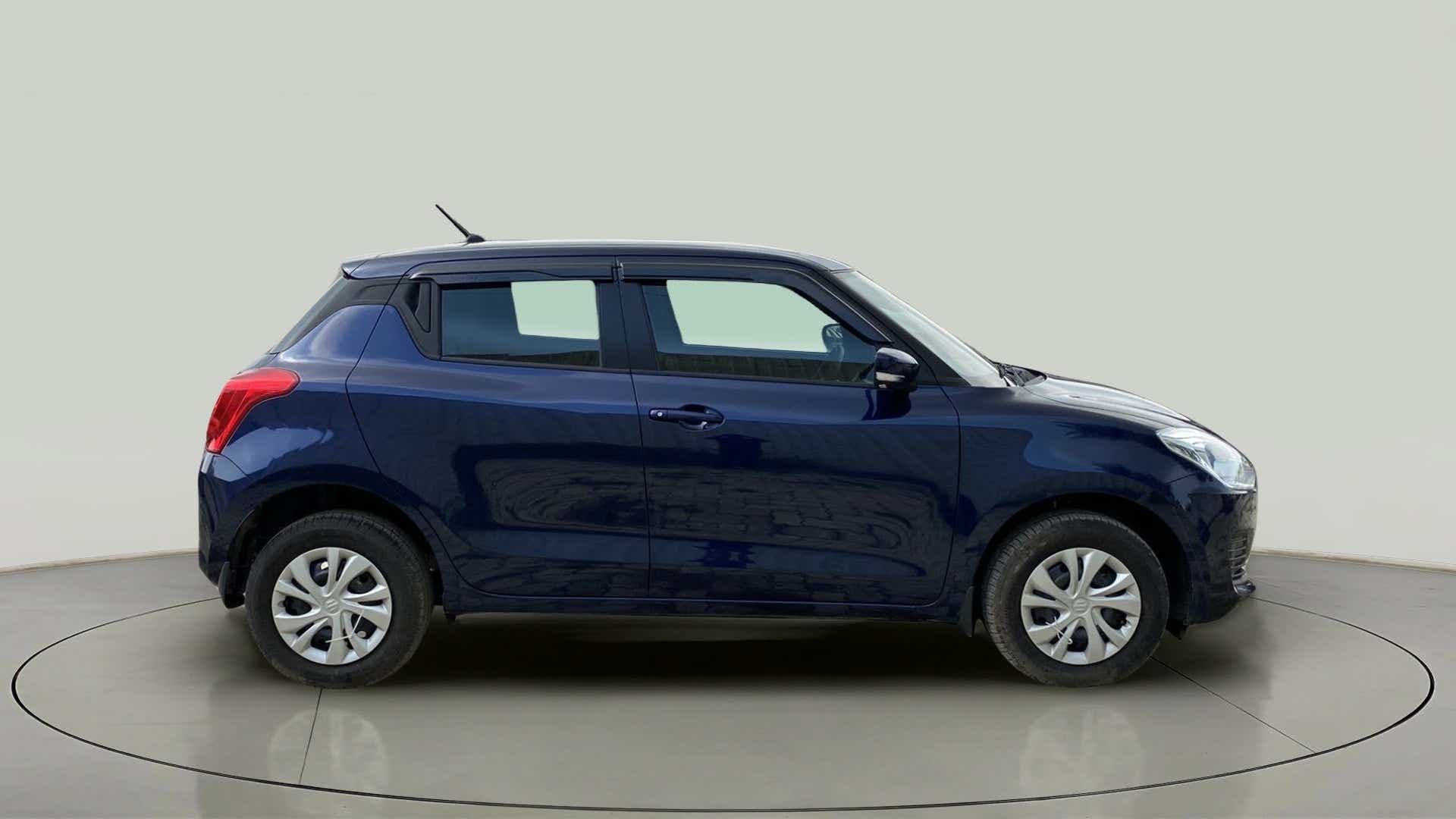 Side view of a pearl metallic midnight blue Maruti Suzuki Swift 2021 - 2023
