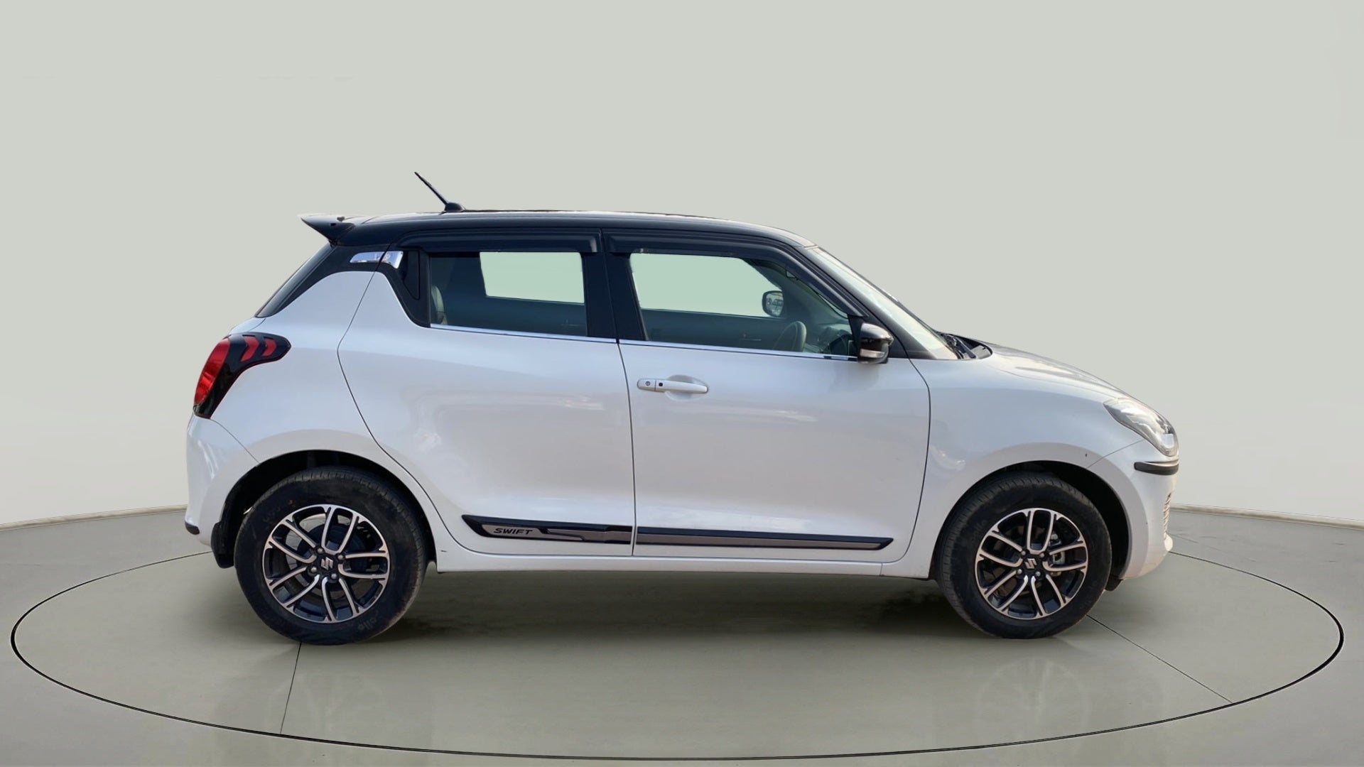 Side view of a pearl arctic white with pearl midnight black roof Maruti Suzuki Swift 2021 - 2023