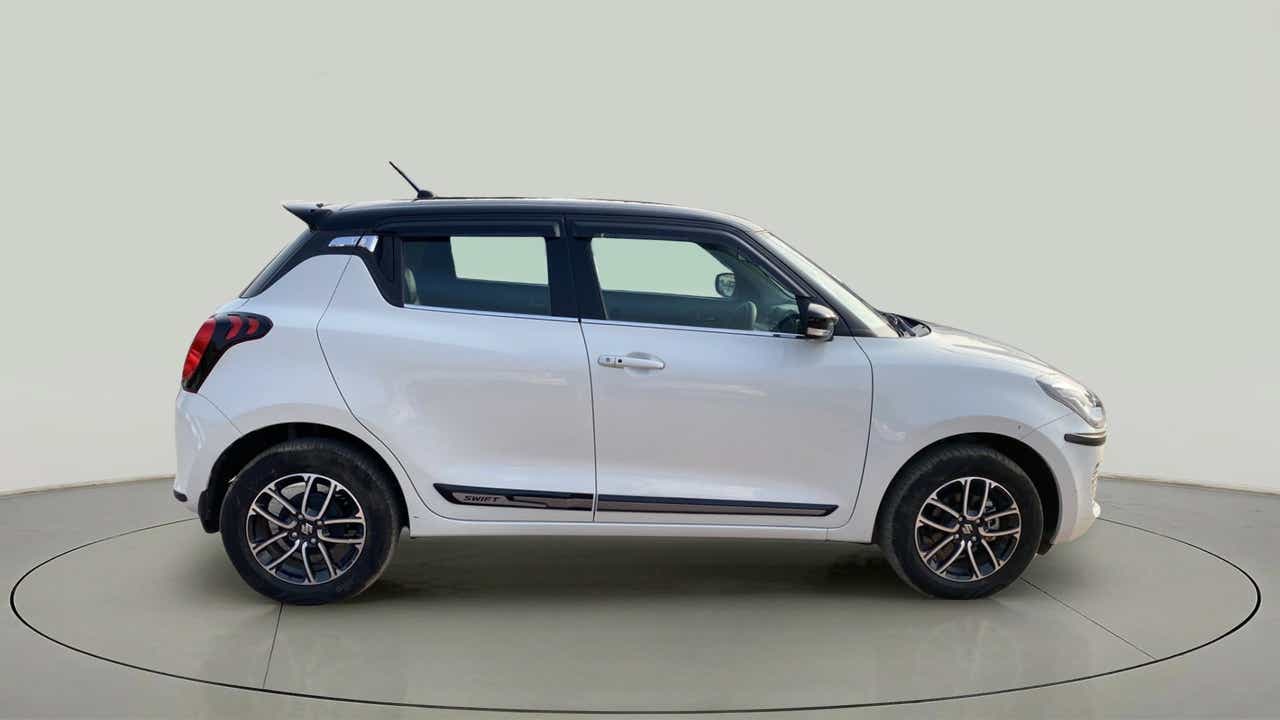 Side view of a pearl arctic white with pearl midnight black roof Maruti Suzuki Swift 2021 - 2023
