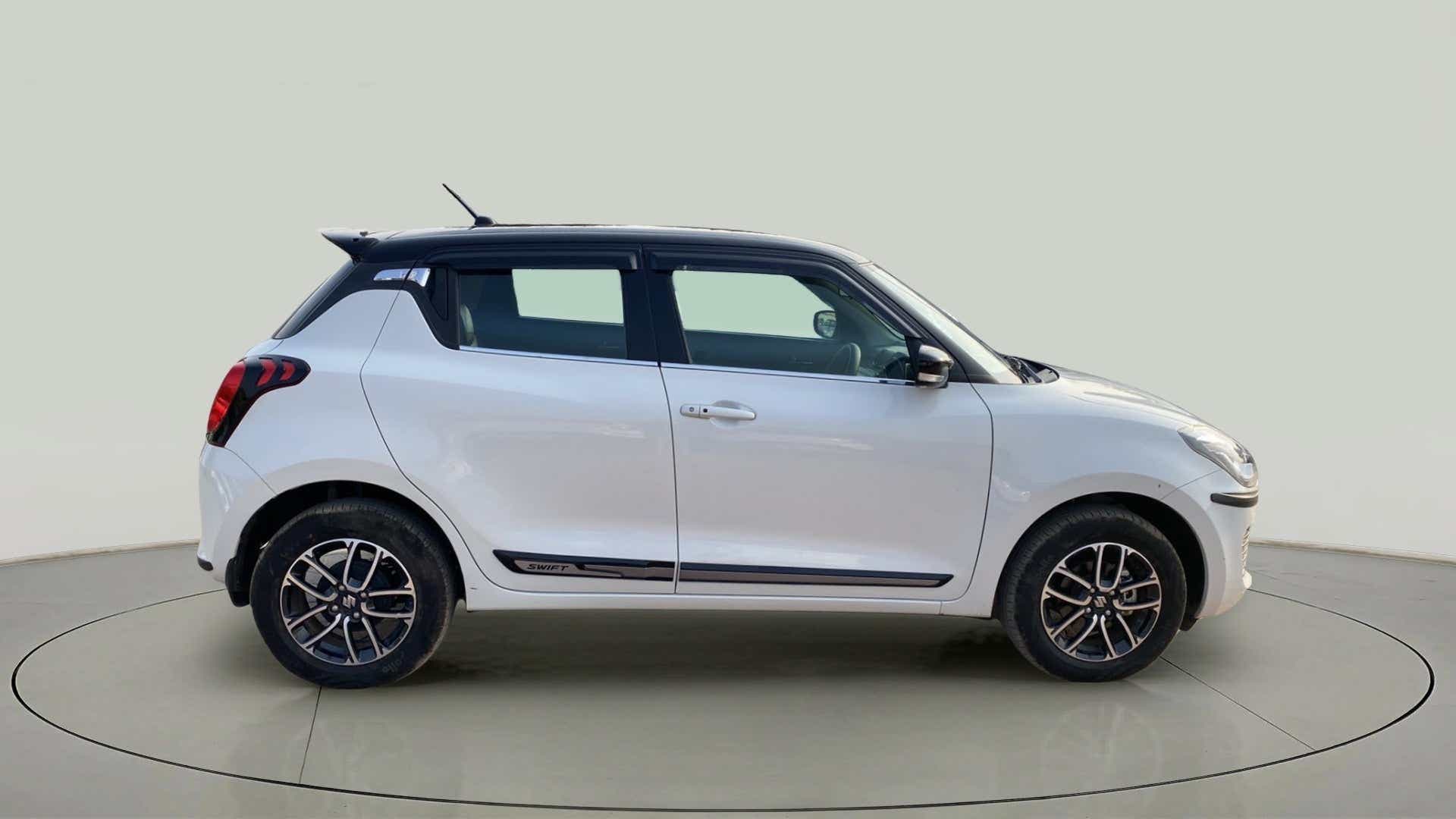 Side view of a pearl arctic white with pearl midnight black roof Maruti Suzuki Swift 2021 - 2023