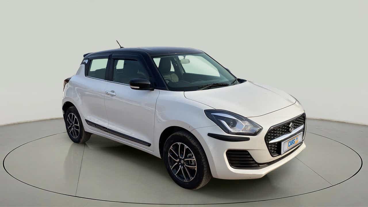 Front three-quarter view of a pearl arctic white with pearl midnight black roof Maruti Suzuki Swift 2021 - 2023