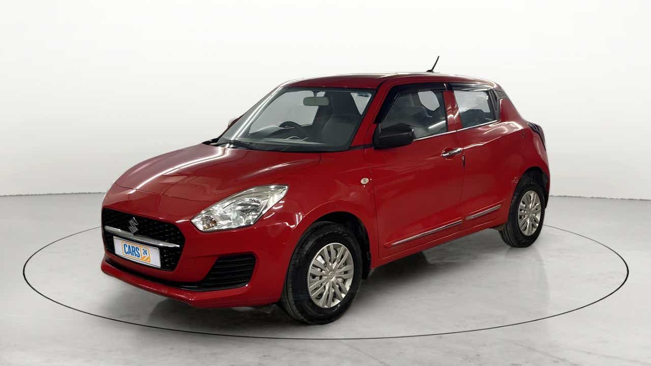 Front three-quarter view of a solid fire red with pearl midnight black roof Maruti Suzuki Swift 2021 - 2023