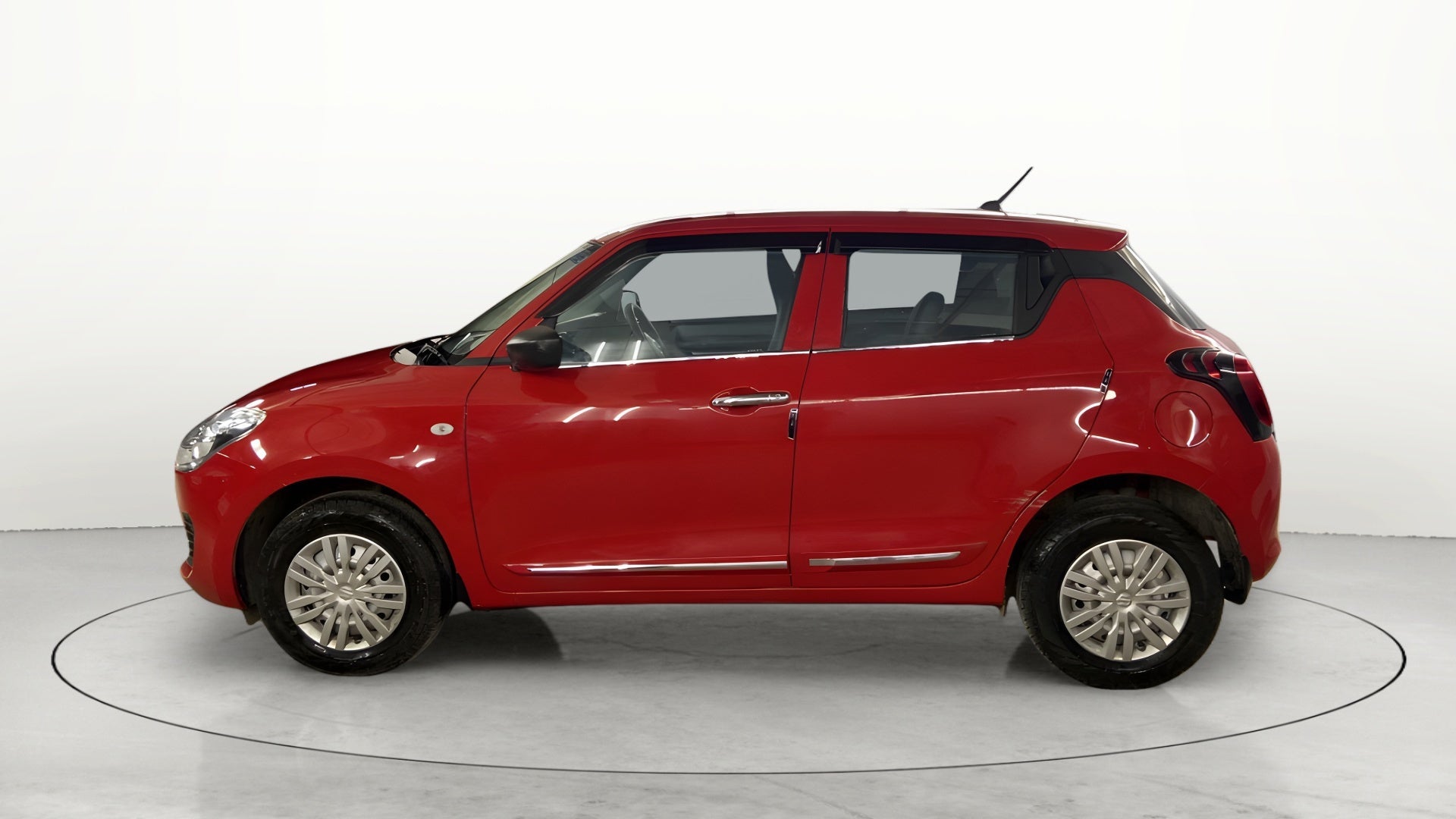 Side view of a solid fire red with pearl midnight black roof Maruti Suzuki Swift 2021 - 2023