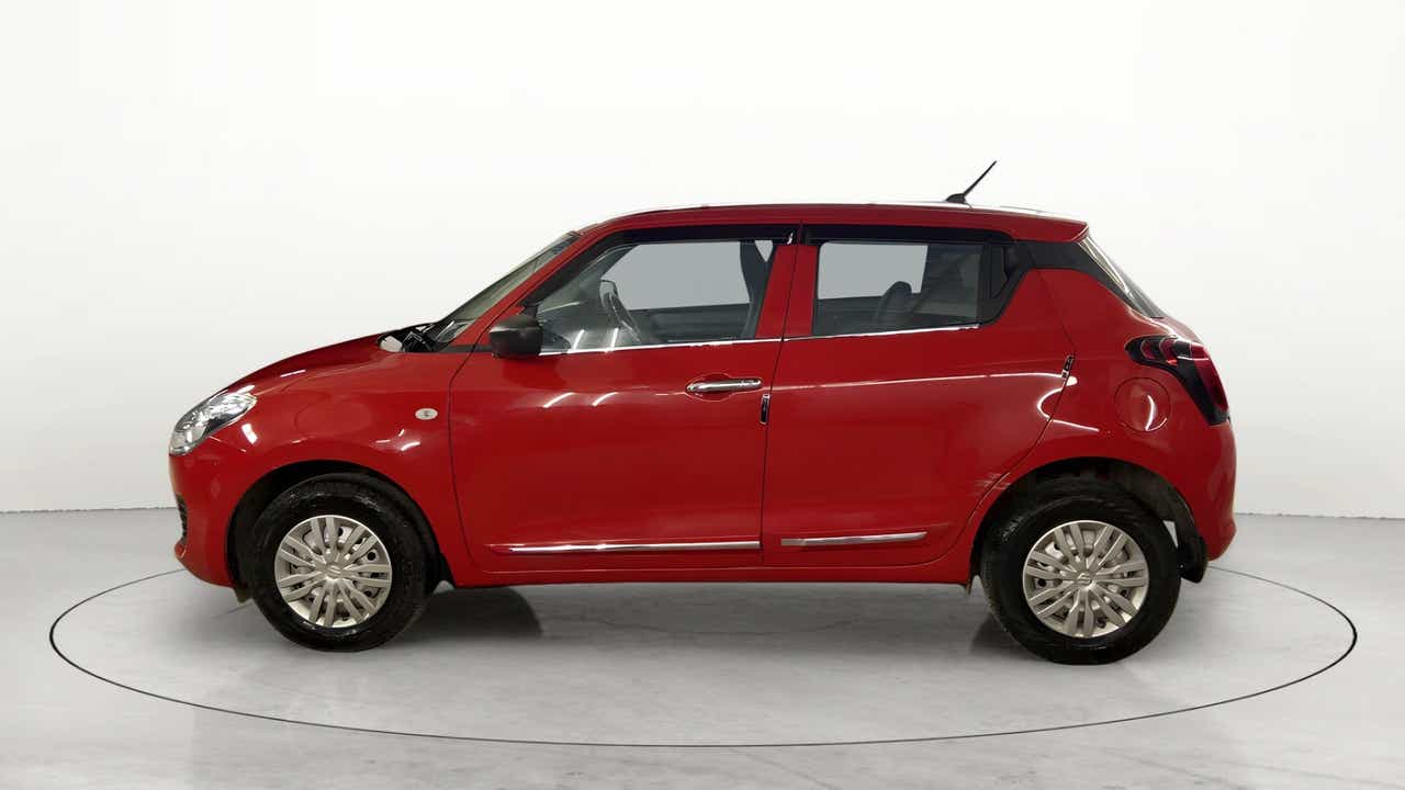 Side view of a solid fire red with pearl midnight black roof Maruti Suzuki Swift 2021 - 2023