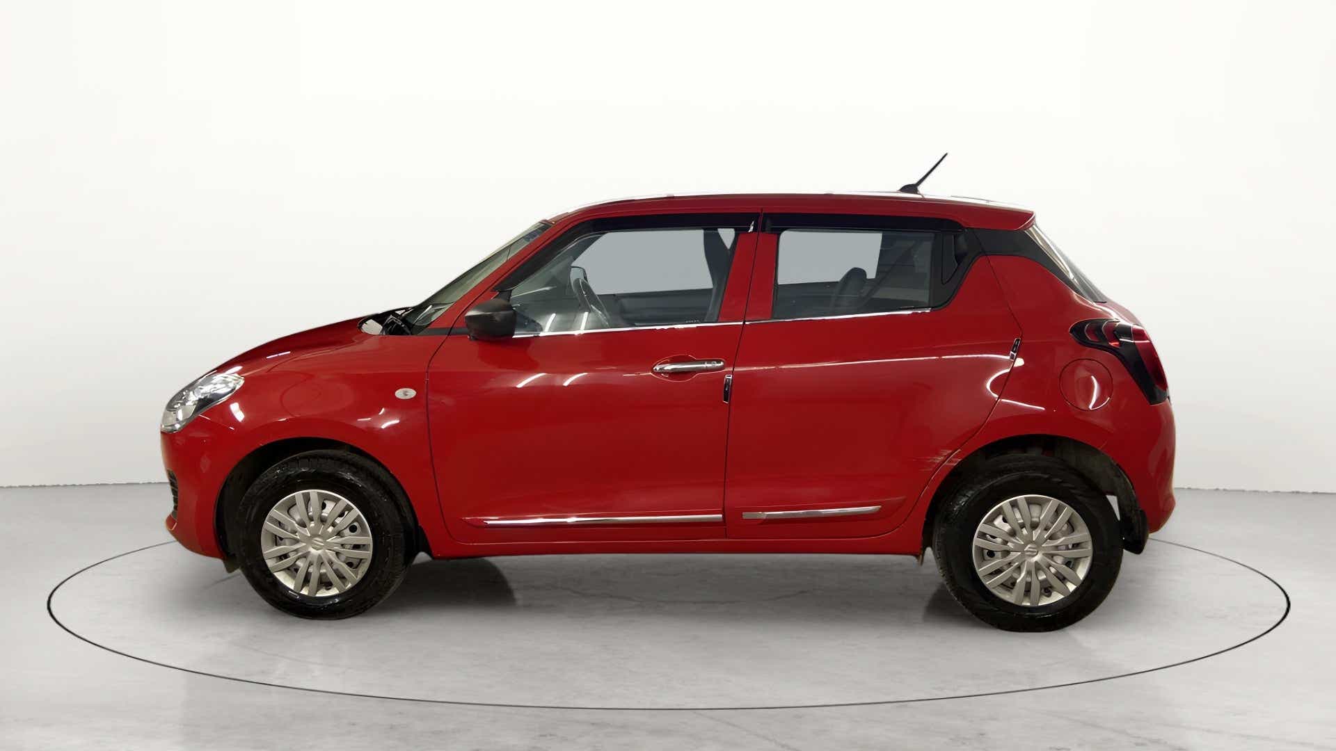 Side view of a solid fire red with pearl midnight black roof Maruti Suzuki Swift 2021 - 2023