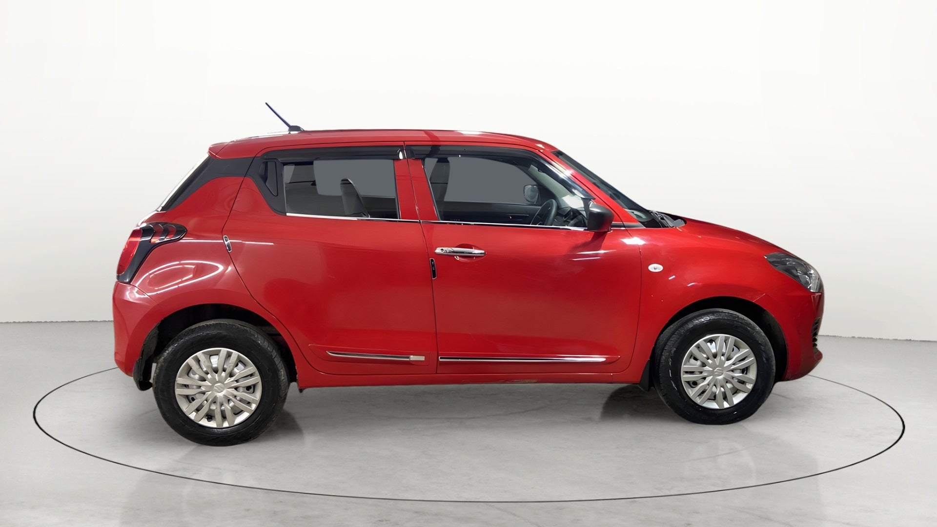 Side view of a solid fire red with pearl midnight black roof Maruti Suzuki Swift 2021 - 2023