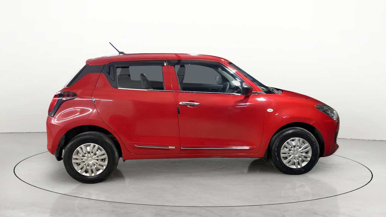Side view of a solid fire red with pearl midnight black roof Maruti Suzuki Swift 2021 - 2023