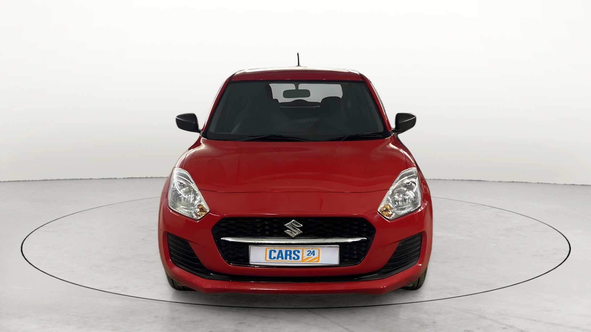 Front view of a solid fire red Maruti Suzuki Swift 2021 - 2023