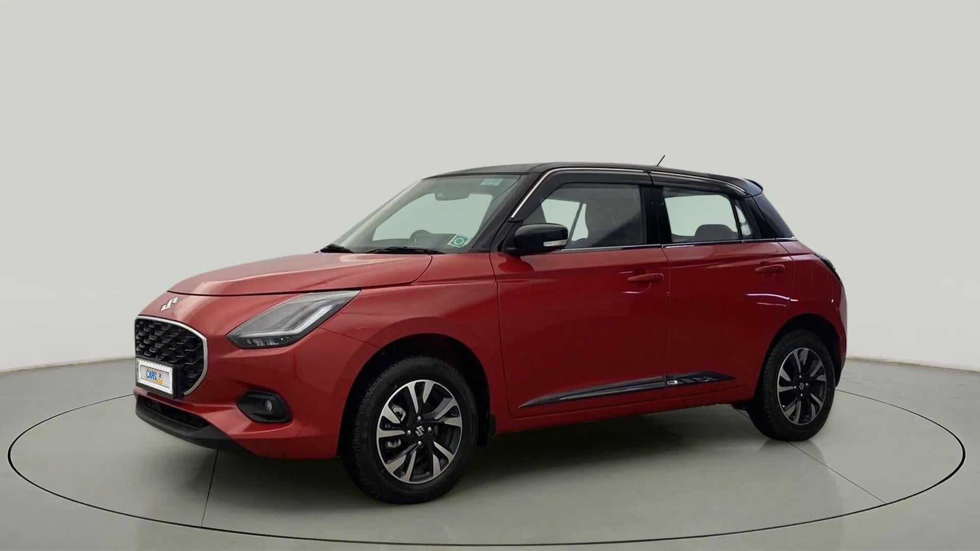 Front three-quarter view of a Sizzling Red with Midnight Black Maruti Suzuki Swift