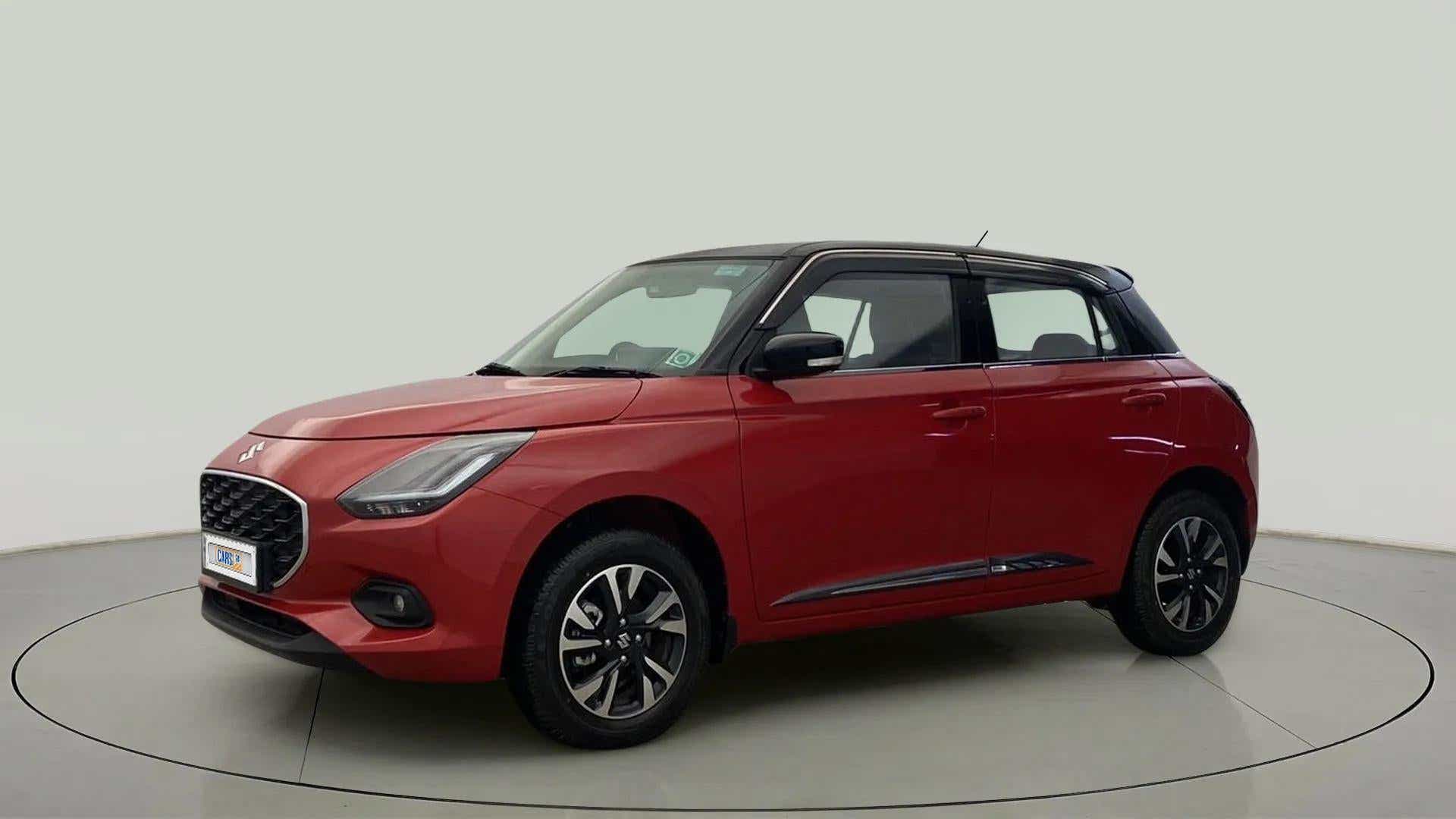 Front three-quarter view of a Sizzling Red with Midnight Black Maruti Suzuki Swift