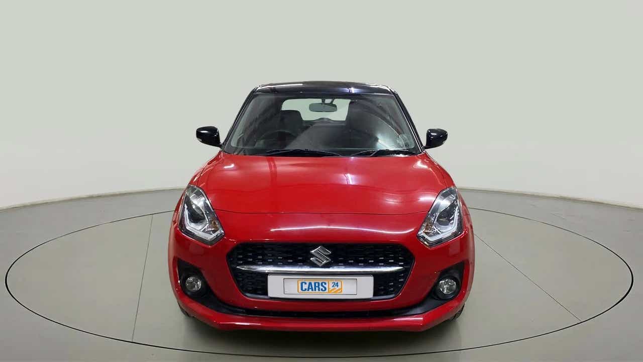 Front view of a solid fire red with pearl midnight black roof Maruti Suzuki Swift 2021 - 2023