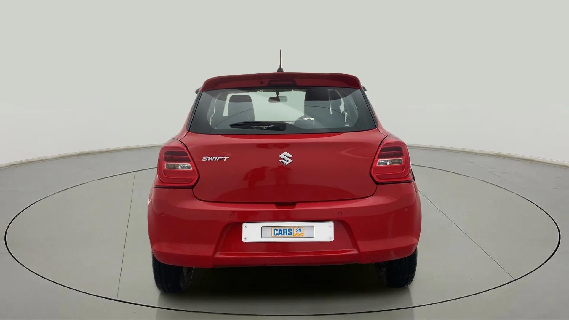 Rear view of a solid fire red maruti suzuki swift 2021 - 2023