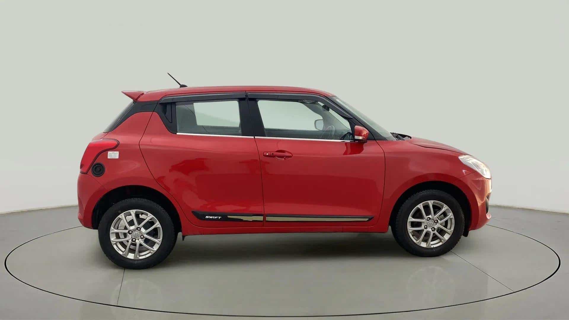 Side view of a solid fire red maruti suzuki swift 2021 - 2023