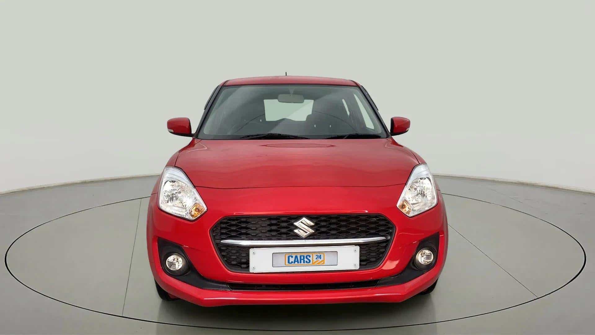 Front view of a solid fire red maruti suzuki swift 2021 - 2023