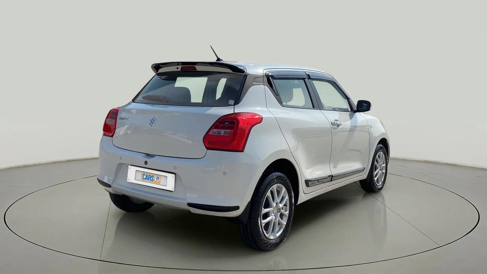 Rear three-quarter view of a Pearl Arctic White with Pearl Midnight Black Maruti Suzuki Swift