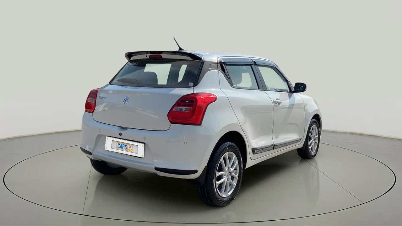 Rear three-quarter view of a Pearl Arctic White with Pearl Midnight Black Maruti Suzuki Swift