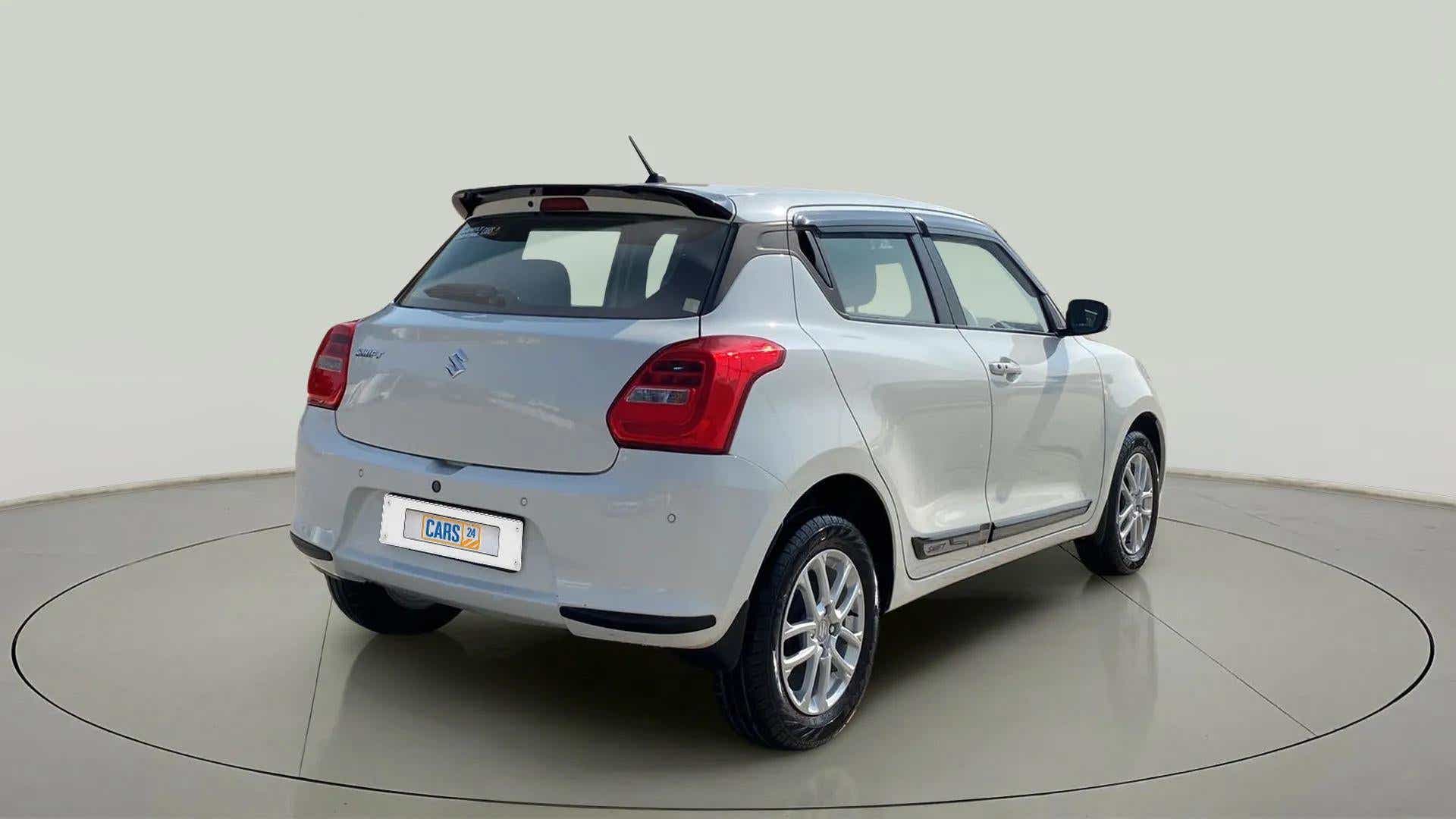 Rear three-quarter view of a Pearl Arctic White with Pearl Midnight Black Maruti Suzuki Swift